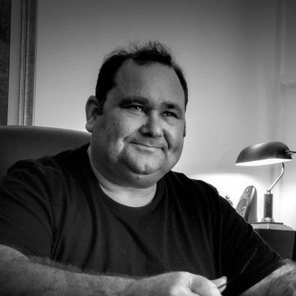 Tony Cullinan working at his desk in the Bega office, in his usual black t-shirt