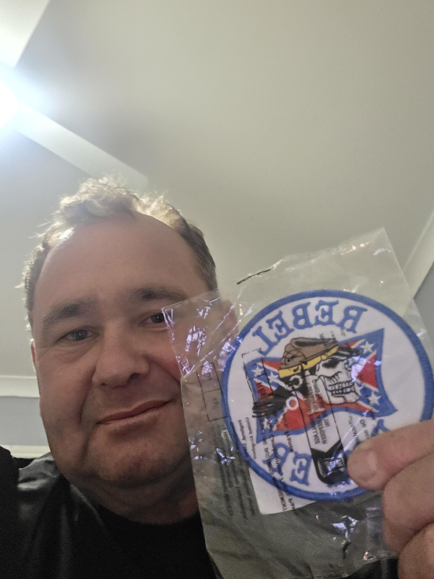 Tony Cullinan holding a Rebel patch